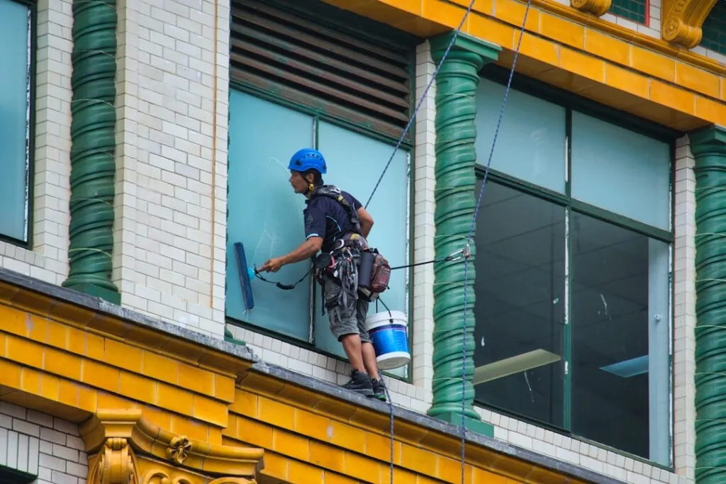 Um Limpador De Janelas Trabalha Alto Na Fachada De Um Predio VLOmD4hVjZk