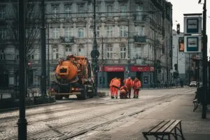 Trabalhadores De Coletes Laranja Com Um Grande Caminhao Laranja muis5J8rO5s